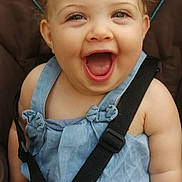 Ana participe au concours pour gagner de l'argent avec cette photo : baby, child, smiling, happy, car_seat, seatbelt, blue_dress, infant, cute, face, skin, cheerful, sitting, straps, young, person, indoors, human, expression, little
