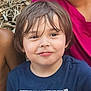 child, boy, smile, face, hair, blue_shirt, teenage_mutant_ninja_turtles, outdoor, wood_chips, person, casual_clothing, happy, portrait, young, nature, expression, sitting, head_and_shoulders, childhood, fun