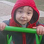 Colson is registered to the contest to win money with this photo: child, hooded_jacket, red_hood, playground, green_bar, smiling, outdoor, park, person, young_child, casual_clothing, hands, face, daylight, recreation, fun, cute, young_person, holding, activity