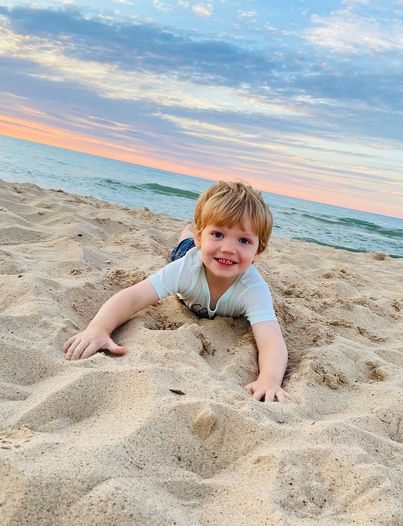 Caden is registered to the contest to win money with this photo: beach, child, cloud, coastal_and_oceanic_landforms, flash_photography, fun, happy, horizon, joy, landscape, leisure, people_in_nature, people_on_beach, person, sitting, sky, smile, toddler, travel, water