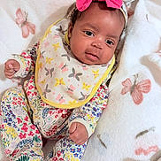 Madisyn joined the competition — help win amazing prizes! baby, infant, child, onesie, bib, headband, bow, blanket, butterfly, floral_pattern, sleepwear, cute, face, skin, hand, footwear, soft_texture, lying_down, indoor, portrait
