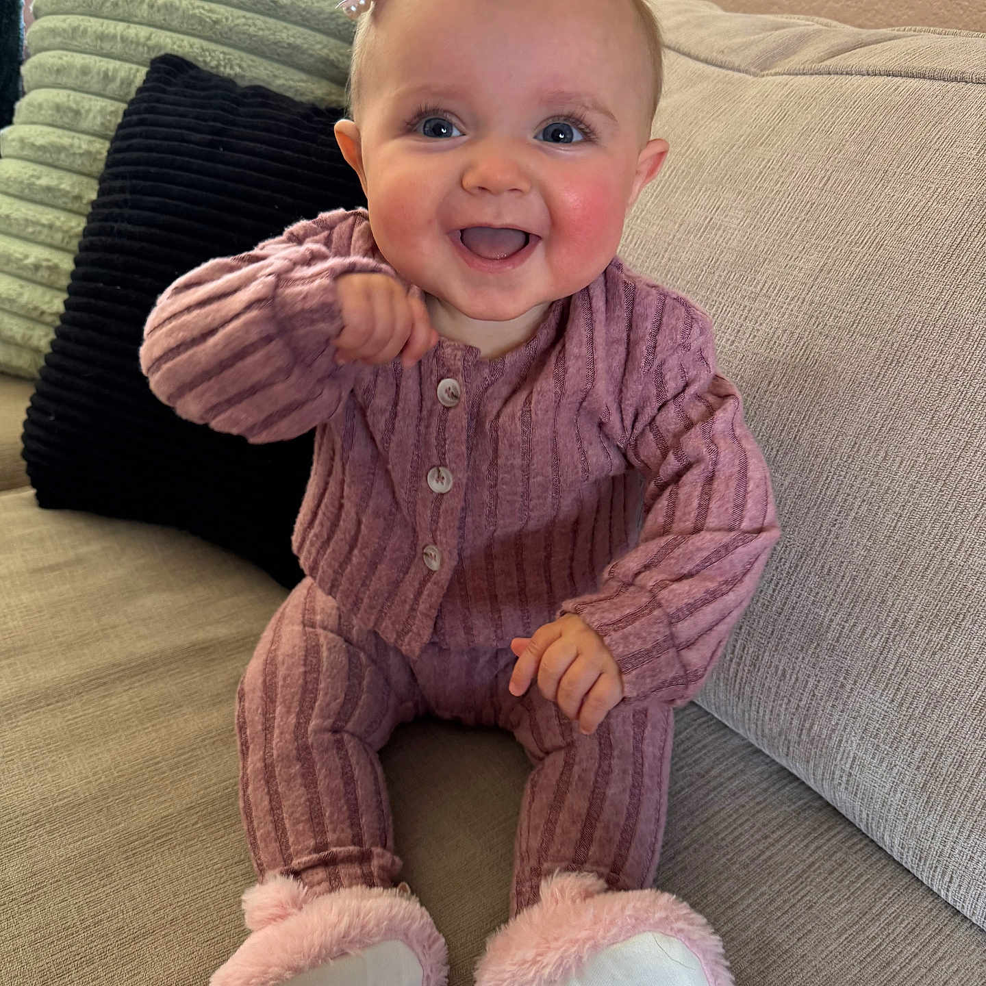 Scarlet joined the competition — help win amazing prizes! baby, child, smiling, sitting, couch, pink_outfit, bow, slippers, indoor, happy, portrait, face, furniture, pillow, cozy, cute, infant, apparel, home, soft