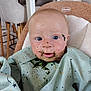 baby, child, high_chair, bib, messy, food, green_food, face, blue_eyes, indoor, kitchen, chair, clothing, person, cute, expression, messy_face, infant, feeding_time, portrait