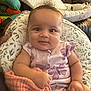 Aurora joined the competition — help win amazing prizes! baby, infant, cute, smiling, clothing, onesie, blanket, curly_hair, pillow, pattern, indoor, couch, hand, face, child, toddler, soft_toy, comfort, expression, seated