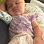 baby, sleeping, infant, purple_outfit, blanket, butterfly_pattern, peaceful, cute, child, soft, cozy, hand, face, indoor, couch, pillow, relaxation, newborn, person, portrait