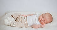 Léo a rejoint le concours — aidez-le/la à gagner de superbes lots ! baby, sleeping, infant, blanket, white_clothing, beige_pants, knitted_booties, soft_texture, peaceful, resting, indoor, portrait, cute, newborn, child, calm, cozy, minimalist, relaxation, lying_down