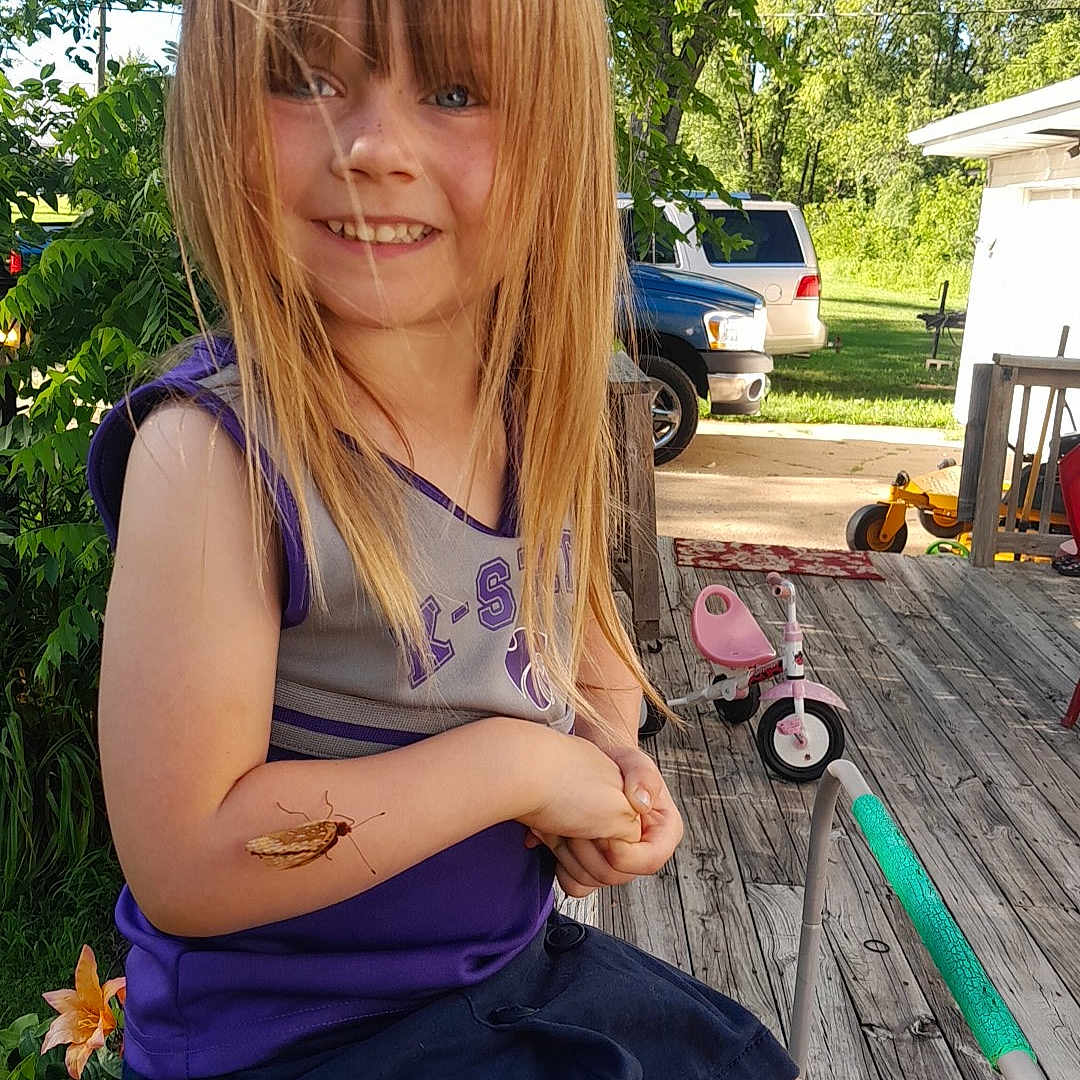 Aliyah is registered to the contest to win money with this photo: architecture, building, child, clothing, dress, face, female, girl, grass, head, house, person, photography, plant, portrait, shorts, sitting, summer, tree, wood