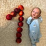 baby, infant, blue_sleeper, nectarines, fruit, number_one, blanket, soft_texture, laying_down, cute, newborn, celebration, fruit_arrangement, pattern, skin, person, young_child, indoors, still_life, sleepwear