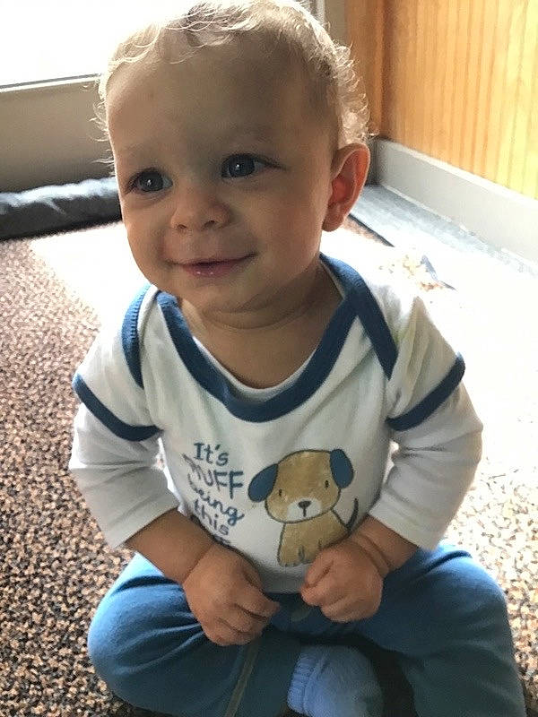 Duquesne is registered to the contest to win money with this photo: baby, baby_toddler_clothing, cheek, child, face, finger, floor, flooring, grass, hairstyle, happy, joy, mammal, person, product, sitting, sleeve, smile, standing, t_shirt