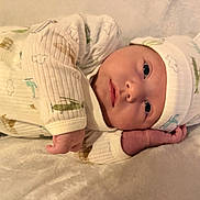 Roman is registered to the contest to win money with this photo: baby, infant, newborn, onesie, hat, soft_texture, blanket, lying_down, cute, face, hand, expression, indoors, cozy, sleepwear, child, portrait, resting, adorable, warm
