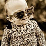 apparel, baby, child, clothing, cute, eyewear, face, fashion, happy, head, heart_shaped, infant, leopard_print, outdoor, person, portrait, smile, stylish, sunglasses, young_child
