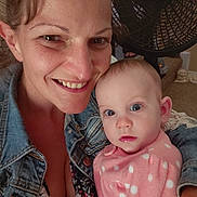 Hope is registered to the contest to win money with this photo: woman, baby, denim_jacket, pink_clothing, polka_dot, face, smile, indoor, fan, carpet, person, child, holding, portrait, closeup, happy, casual, home, light, expression
