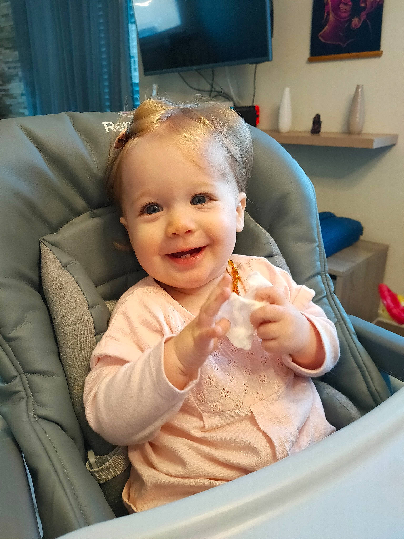 Flora participe au concours pour gagner de l'argent avec cette photo : arm, baby, baby_toddler_clothing, blond, chair, cheek, child, comfort, facial_expression, fun, gesture, happy, joy, mammal, person, picture_frame, product, skin, smile, television