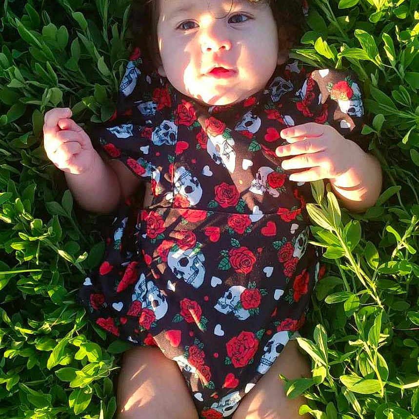 Iris is registered to the contest to win money with this photo: baby, clothing, dress, face, grass, green, head, herbal, herbs, lawn, leaf, nature, outdoors, person, photography, plant, portrait, summer, vegetation, yard