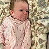 baby, infant, pink_onesie, cherry_pattern, blanket, floral_blanket, soft_texture, lying_down, indoors, cute, child, young, skin, face, head, expression, cozy, pout, sleepwear, warm