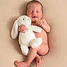 baby, newborn, smiling, plush_toy, bunny, soft_texture, naked, sleeping, cute, infant, child, resting, peaceful, background, studio, portrait, skin, hand, foot, cuddly