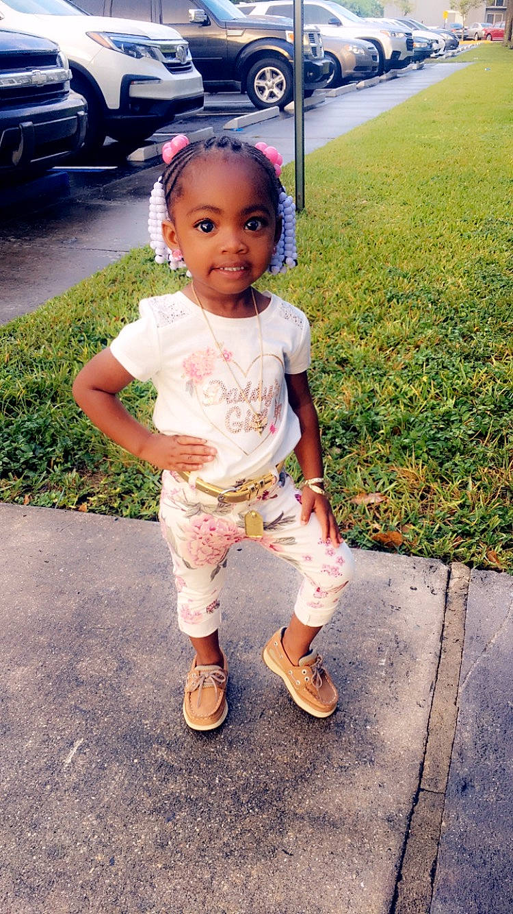 Alani is registered to the contest to win money with this photo: baby, child, footwear, head, person, plant, shoe, skin, smile, standing, toddler, vacation