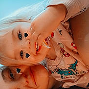 Athena is registered to the contest to win money with this photo: child, toddler, sibling, selfie, heart_stickers, pajamas, blonde_hair, smile, freckles, snack, hand, face, eyes, indoor, cozy, portrait, closeup, wall_outlet, casual_clothing, playful