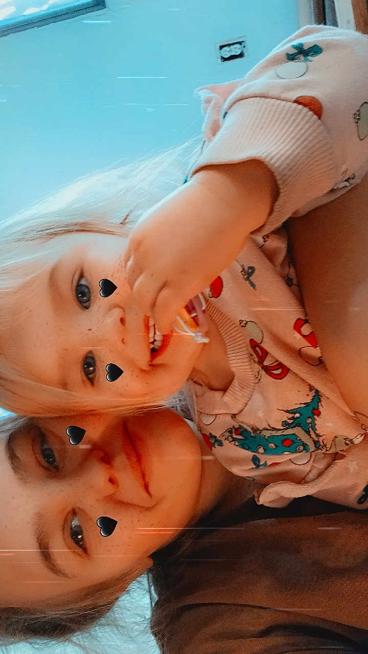 Athena is registered to the contest to win money with this photo: child, toddler, sibling, selfie, heart_stickers, pajamas, blonde_hair, smile, freckles, snack, hand, face, eyes, indoor, cozy, portrait, closeup, wall_outlet, casual_clothing, playful