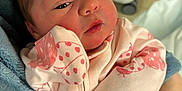 Ivory is registered to the contest to win money with this photo: newborn, baby, infant, person, face, clothing, pink, polka_dots, hand, blanket, sleepy, cute, portrait, indoors, holding, close_up, skin, head, eyes, young_child