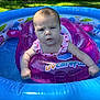 baby, inflatable_ring, pool, water, outdoor, summer, child, swimming, float, grass, tree, sunlight, pink_clothing, expression, backyard, recreation, play, person, daylight, inflatable_pool