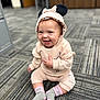 baby, child, smiling, hoodie, mouse_ears, sitting, carpet, indoor, cute, happy, person, clothing, footwear, socks, patterned_floor, infant, portrait, candid, casual_wear, playful