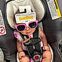 baby, car_seat, sunglasses, pacifier, infant, child, pink, clothing, harness, seat_belt, cute, sitting, indoors, warning_label, strap, accessory, person, small, funny, packaging