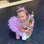 award, bow, celebration, child, cute, dance, dress, event, floor, fun, girl, happy, indoor, person, purple, shoes, smile, sparkly, trophy, young