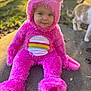 Ivory is registered to the contest to win money with this photo: toddler, child, costume, pink, fuzzy, rainbow, outdoor, sidewalk, cat, animal, sunlight, cute, portrait, smiling, hood, playful, baby, person, nature, fun