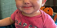 Lillian is registered to the contest to win money with this photo: toddler, child, smiling, pink_shirt, baby_walker, indoor, face, happy, person, blue, furniture, couch, toy, hair, eyes, mouth, skin, clothing, seat, infant