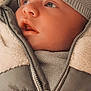 baby, face, child, winter_clothing, hat, jacket, zipper, knitwear, warm, close_up, portrait, soft_texture, curious, infant, looking_away, apparel, bundle_up, outerwear, cute, young_child
