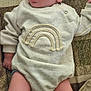 baby, infant, child, lying_down, patterned_fabric, clothing, socks, face, legs, cute, looking_up, cozy, soft_texture, indoor, expression, human, newborn, adorable, casual, comfort
