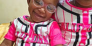 Kay'Cee joined the competition — help win amazing prizes! child, children, closeup, curly_hair, cute, girl, glasses, happy, headband, indoor, jewelry, matching_outfits, necklace, person, pink, portrait, sitting, smile, toddler, white