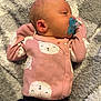 baby, blanket, clothing, coat, couch, cushion, face, furniture, head, homedecor, jacket, knitwear, newborn, pants, person, photography, portrait, quilt, sleeping, sweater
