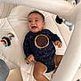 baby, infant, play_mat, onesie, toy, smiling, happy, indoor, child, play_gym, white, fabric, star_pattern, book, crawling, cute, young_child, person, floor, colorful_toy