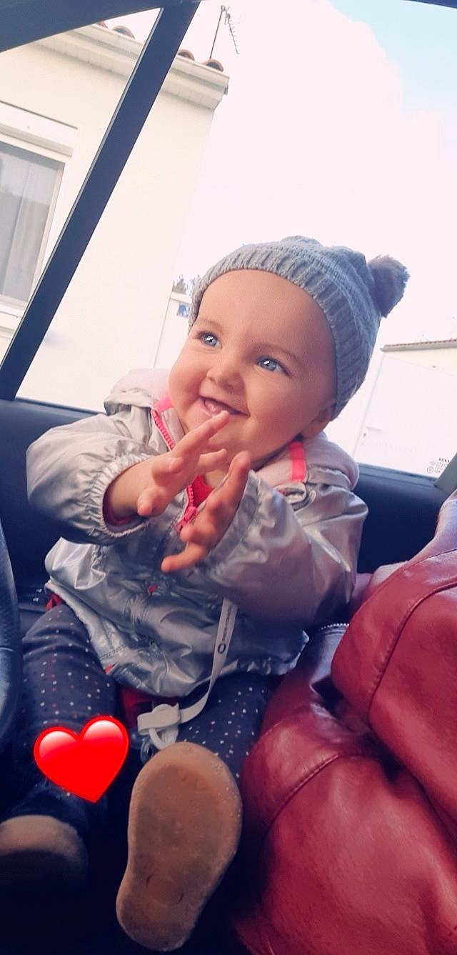 Emmy participe au concours pour gagner de l'argent avec cette photo : balloon, cap, car_seat, finger, fun, gesture, hand, happy, headgear, headwear, human_body, joy, lap, lip, mouth, nail, person, pink, skin, smile