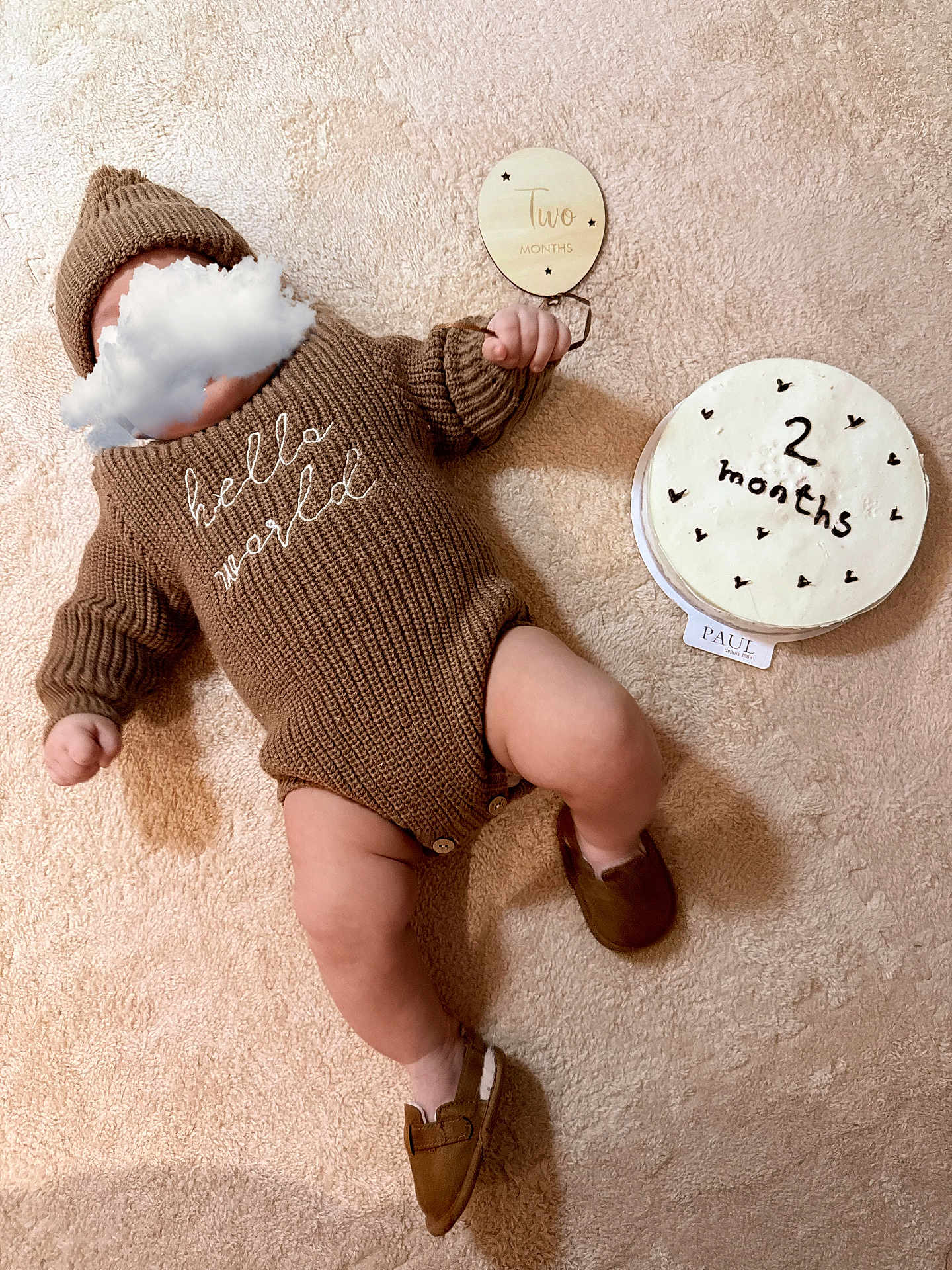 Noah participe au concours pour gagner de l'argent avec cette photo : baby, infant, milestone, two_months, knitted_sweater, beanie, cake, milestone_card, plush_blanket, cozy, top_view, lying_down, shoe, legs, hand, neutral_background, brown_tones, celebration, cloud_sticker, hello_world_text
