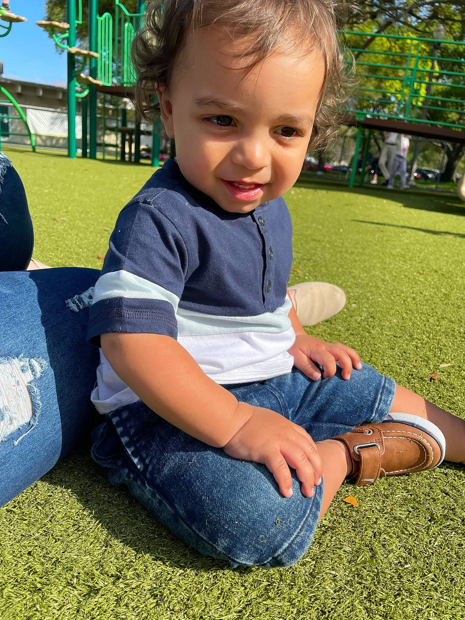 Junior is registered to the contest to win money with this photo: child, facial_expression, finger, fun, grass, hair, hand, happy, jeans, lawn, leaf, leisure, people_in_nature, person, plant, recreation, smile, summer, sunlight, toddler