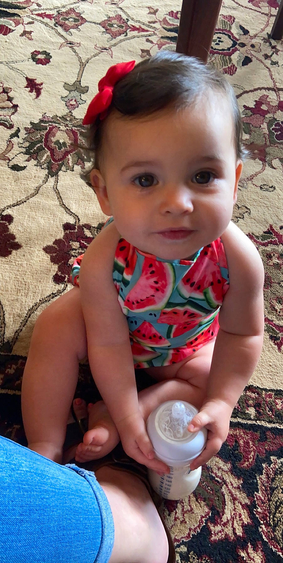 Emrie is registered to the contest to win money with this photo: baby, baby_toddler_clothing, blue, cheek, child, dress, drinkware, face, fun, grass, hairstyle, happy, head, pattern, people_in_nature, person, pink, product, sitting, skin