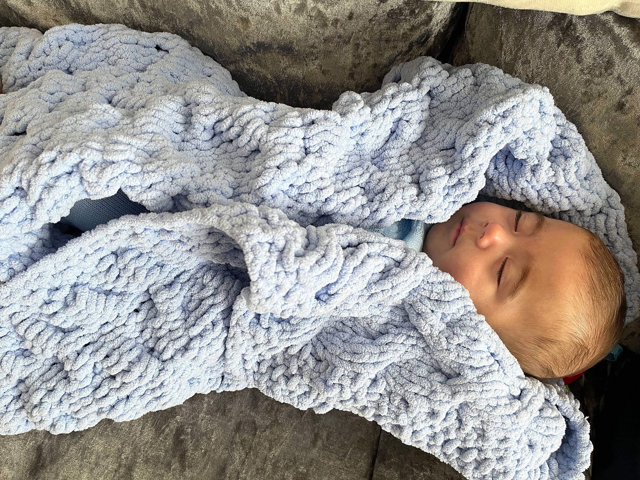 Louie is registered to the contest to win money with this photo: bedrock, cap, comfort, eye, geology, grey, hand, head, headgear, human_body, linens, outerwear, person, rock, textile, toddler, tree, trunk, vertebrate, wood