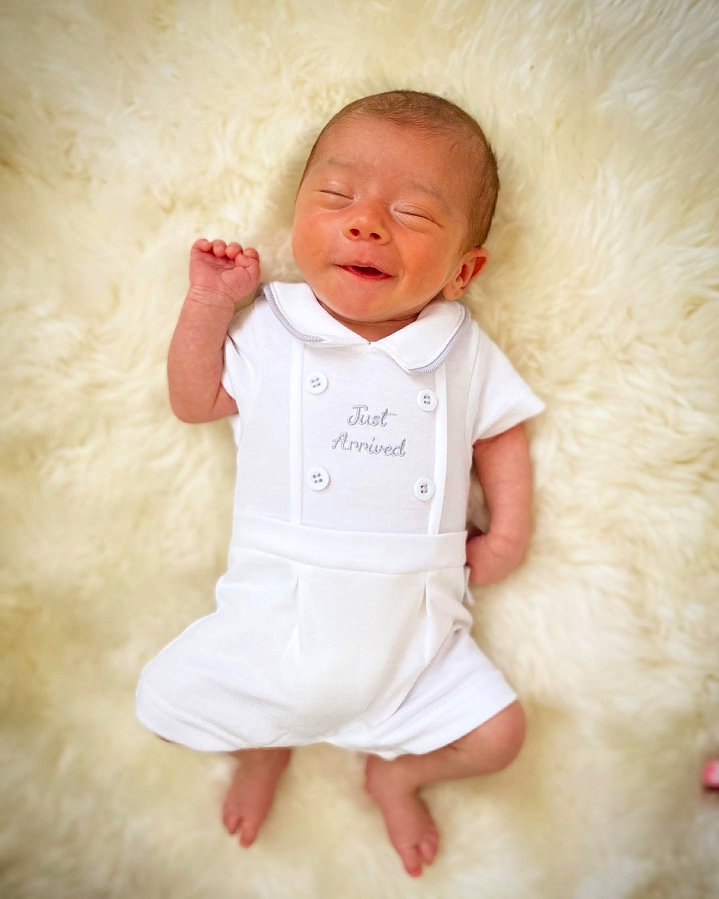 Louie is registered to the contest to win money with this photo: arm, baby, baby_toddler_clothing, cheek, collar, comfort, dress_shirt, eye, face, flash_photography, gesture, happy, leg, neck, outerwear, person, pink, skin, sleeve, textile