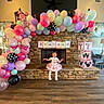 Ava is registered to the contest to win money with this photo: child, balloons, birthday, party, tutu, pink, decoration, indoor, hearth, stone_wall, blocks, flooring, smile, celebration, festive, girl, dress, event, colorful, happy