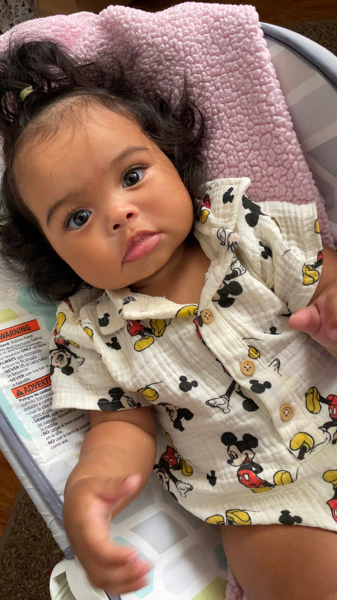 Leilani joined the competition — help win amazing prizes! baby, infant, child, mickey_mouse, shirt, clothing, blanket, baby_seat, soft_texture, curly_hair, cute, hand, face, eyes, indoor, comfort, portrait, expression, young_child, baby_girl