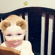 River is registered to the contest to win money with this photo: baby, bars, bear_ears, child, crib, cute, eyes, face, filter, hand, hearts, indoor, infant, nursery, playful, portrait, smile, sparkles, toddler, wooden_rail