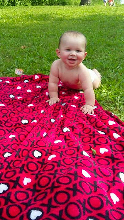 Zavier is registered to the contest to win money with this photo: child, day, facial_expression, flooring, flower, fun, girl, grass, infant, joy, lawn, magenta, petal, pink, plant, play, recreation, red, smile, summer