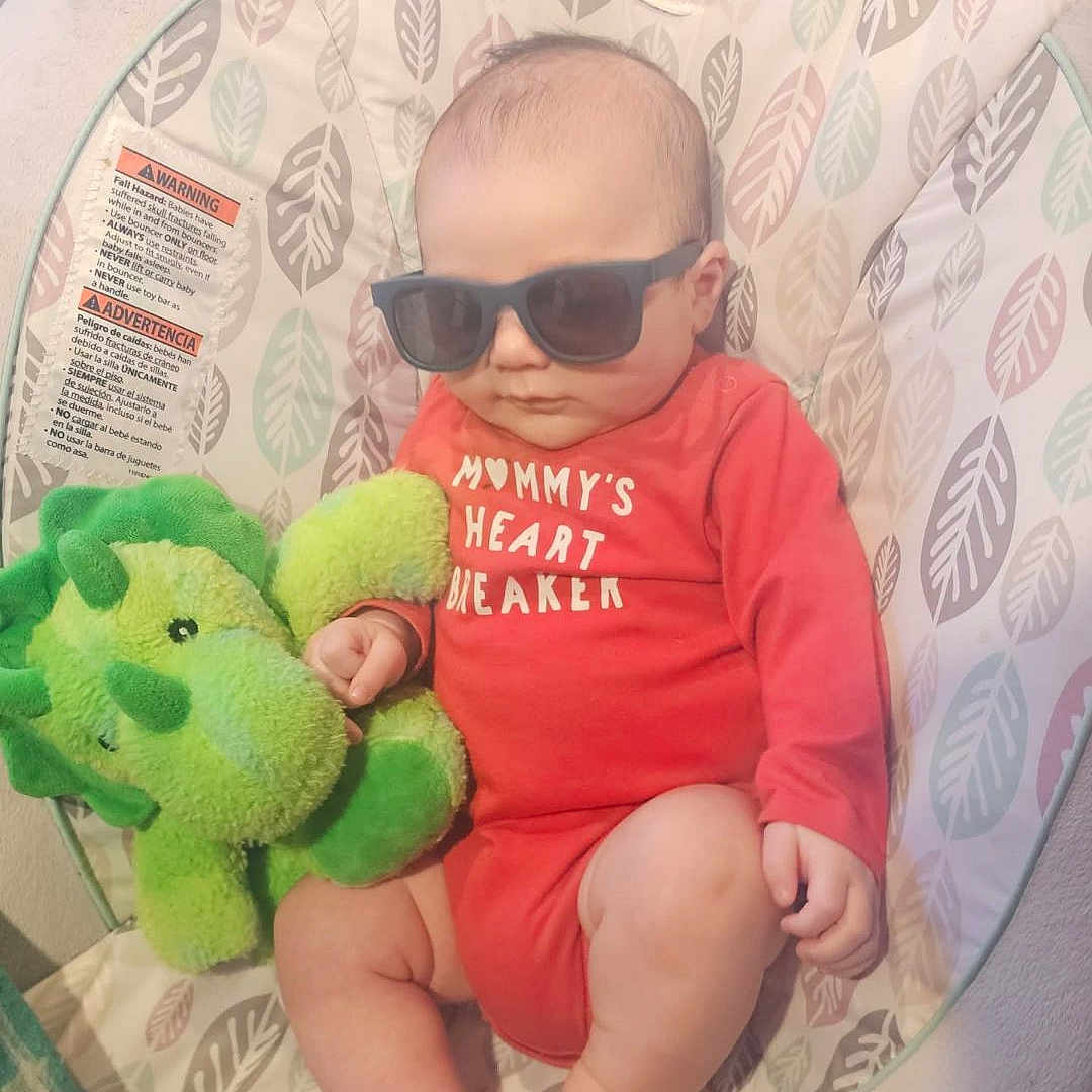 Myles joined the competition — help win amazing prizes! baby, baby_chair, bouncer, child, cute, dinosaur_toy, fashionable, indoors, infant, leaf_pattern, patterned_fabric, photography, plush_toy, portrait, red_outfit, relaxed, seated, sunglasses, toes, toy