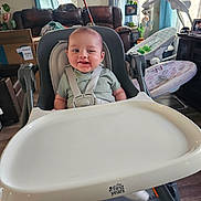 Myles joined the competition — help win amazing prizes! baby, baby_gear, child, curtains, face, feeding, framed_photos, green_shirt, happy, harness, high_chair, home, indoor, infant, living_room, portrait, sitting, smiling, sofa, television
