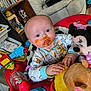 Phoebe is registered to the contest to win money with this photo: baby, child, messy_face, blue_eyes, activity_center, toy, plush_toy, minnie_mouse, indoor, clothing, hands, face, expression, seat, floor, furniture, wood_floor, shelf, container, diapers