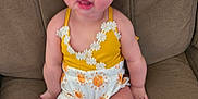 Phoebe joined the competition — help win amazing prizes! arms, baby, child, clothing, couch, cute, face, furniture, happy, indoors, infant, legs, person, portrait, sitting, smiling, sun_pattern, white, yellow, young