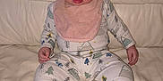 Phoebe joined the competition — help win amazing prizes! baby, infant, child, pajamas, bib, socks, striped_socks, sitting, couch, leather, cream_color, cute, indoor, portrait, face, hands, feet, expression, patterned_clothing, cozy